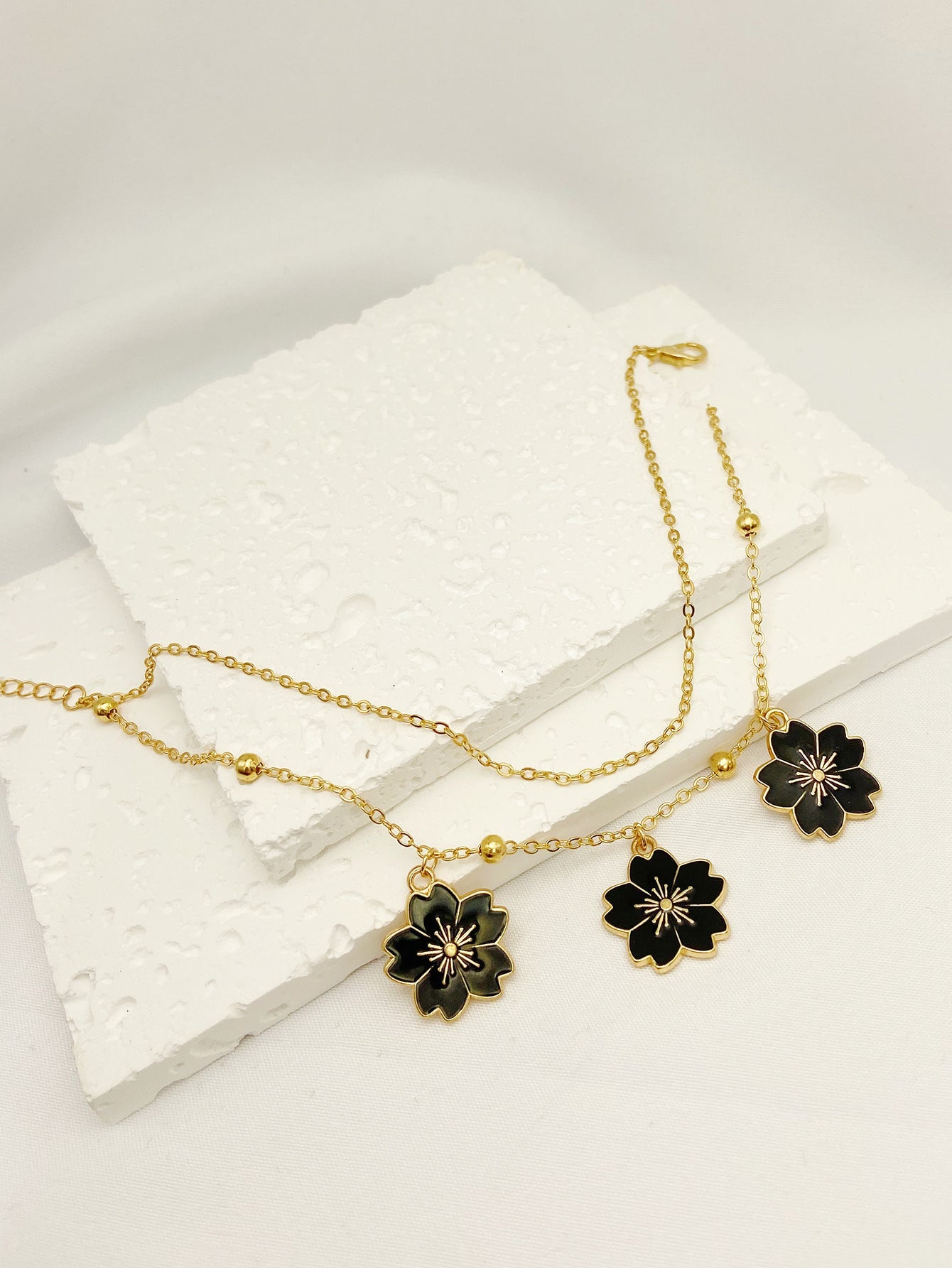 Schlichtes doppellagiges Fußkettchen mit Blumenanhänger und Ölfleckglasur